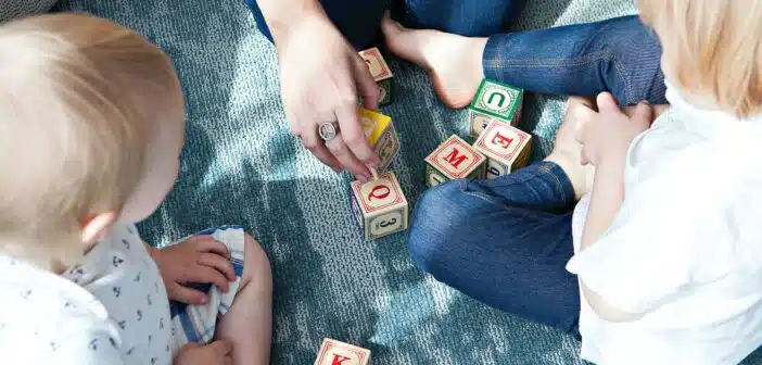 two toddler playing letter cubes