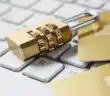 a golden padlock sitting on top of a keyboard
