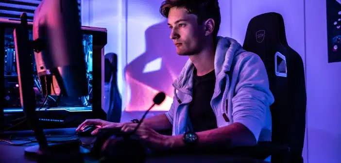 a man sitting in front of a computer monitor