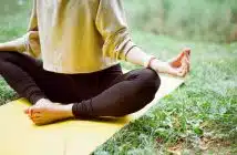 une femme pratiquant le yoga dans son jardin