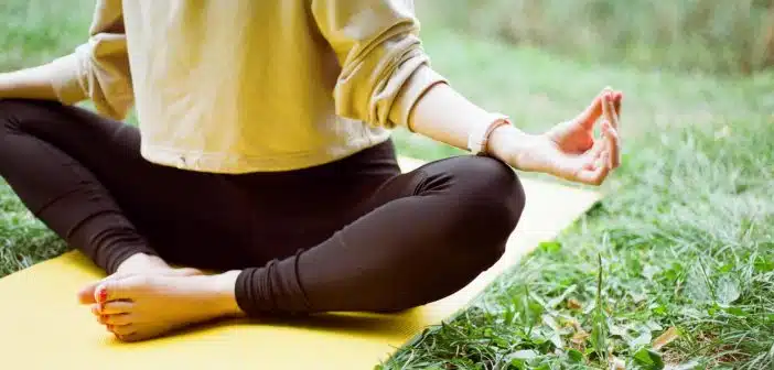 une femme pratiquant le yoga dans son jardin