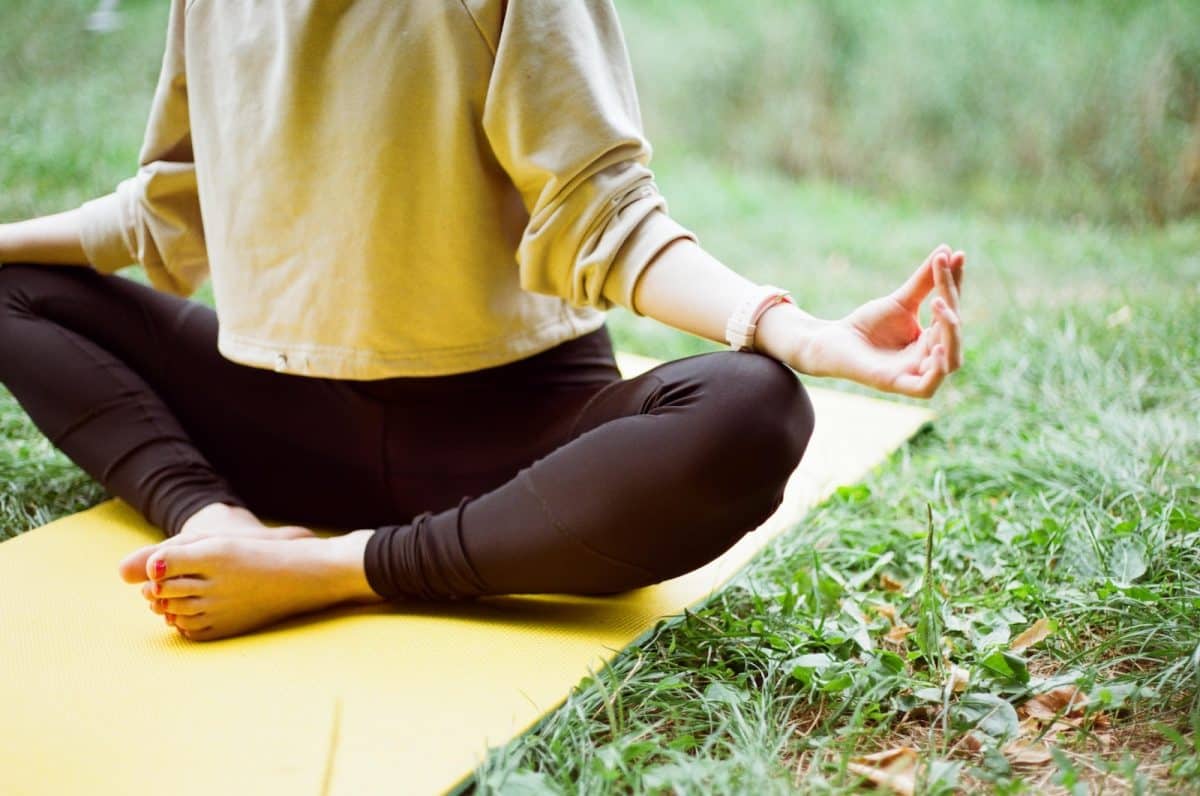 une femme pratiquant le yoga dans son jardin